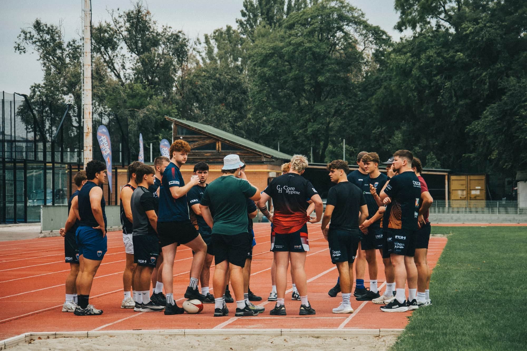 Athletes in a team huddle on a running track