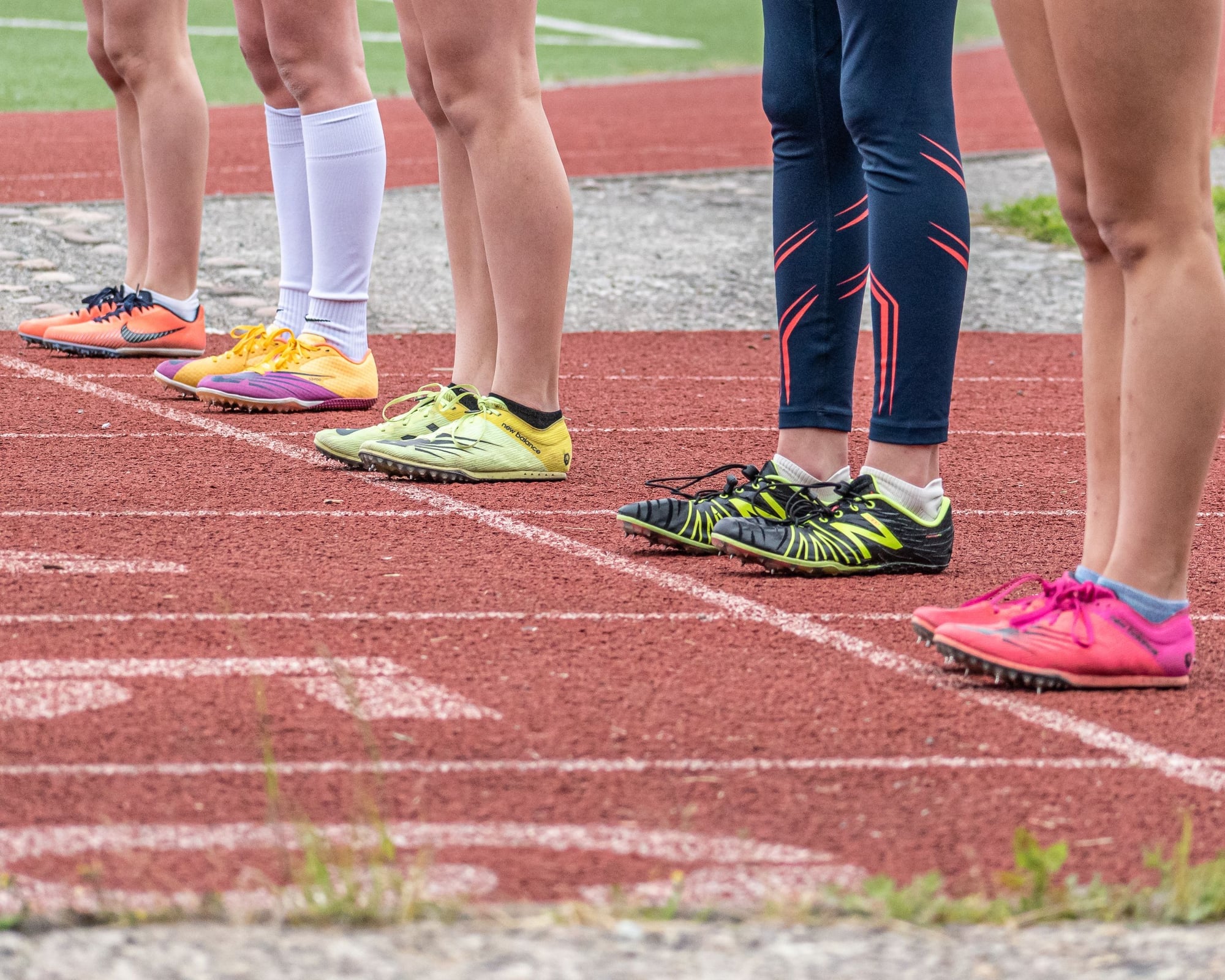 Runners' lower legs and running shoes on a running track