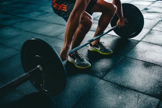 Runner and athlete doing lunges in a gym
