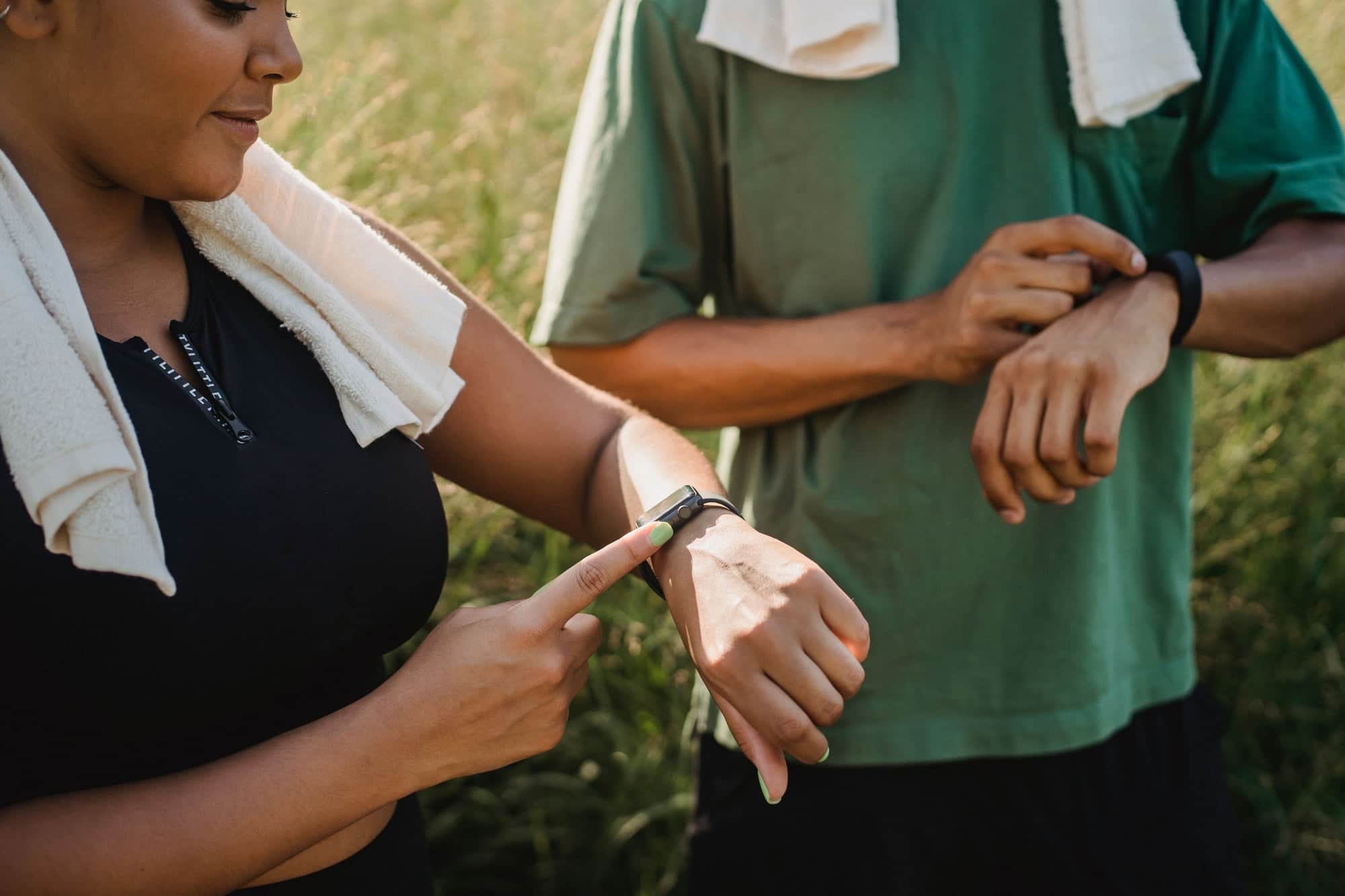 Two athletes checking their watches