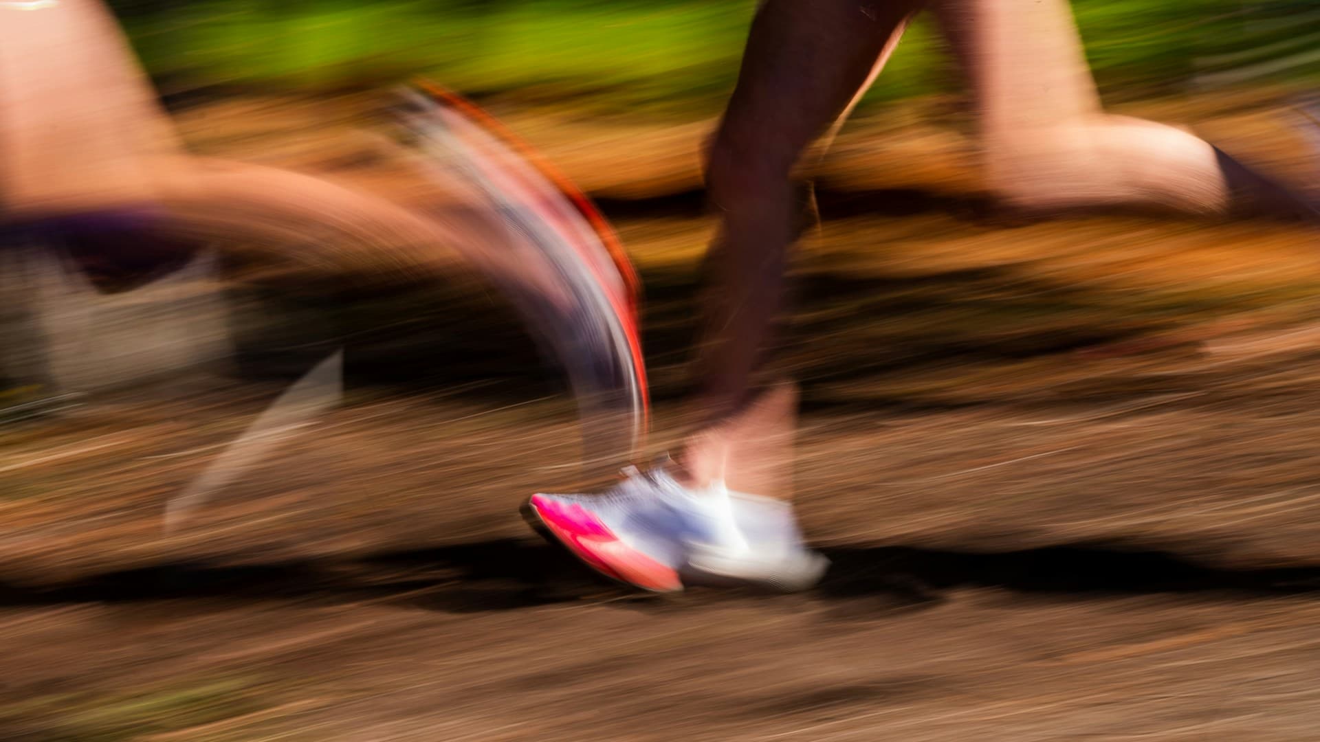 Runner accelerating across a city bridge at sunset